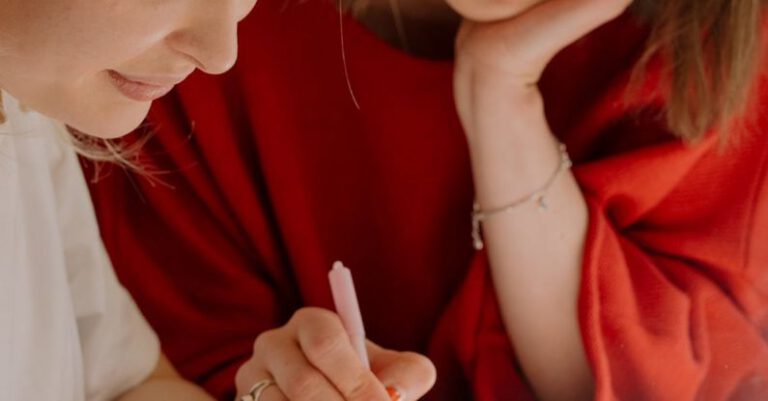 Peer Tutoring - Woman in Red Shirt Holding Pen Writing on White Paper