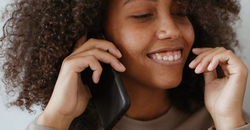 Smartphone - A Woman Wearing a Brown Sweater on a Phone Call