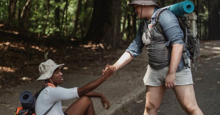Fitness Journey - Hiker holding hand of black friend on road