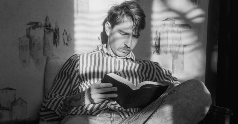 Speed Reading - Man Sitting with Book in Black and White